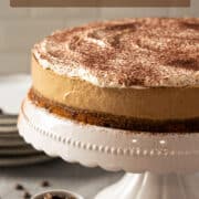 A whole no-bake coffee cheesecake on a cake stand.