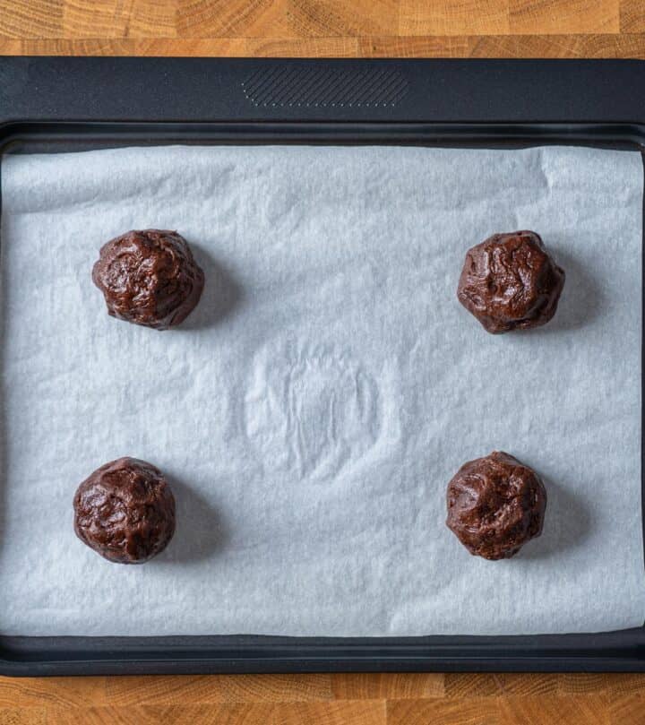 Placing shaped balls on a tray to bake.