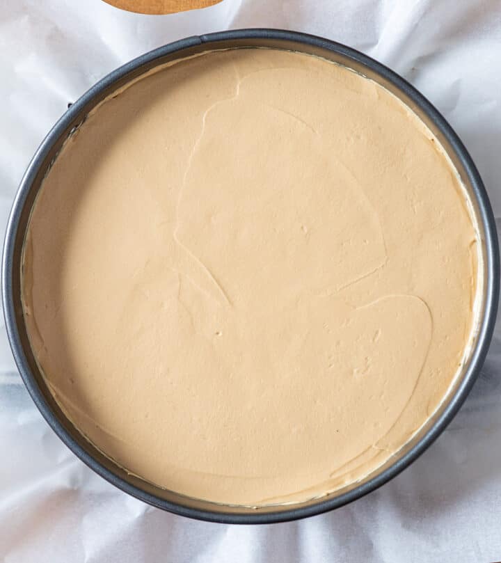 Spreading cheesecake filling on the crust.