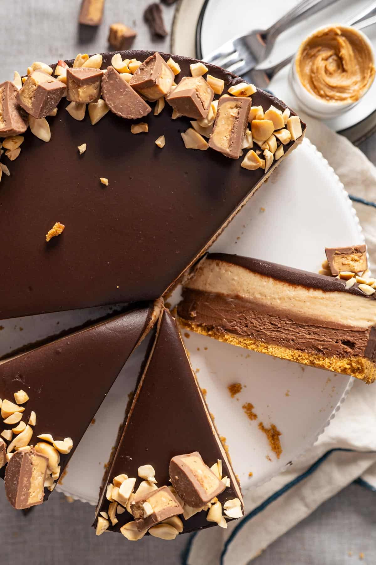 Top view of no bake peanut butter cheesecake on a cake stand with one slice flipped on the side.