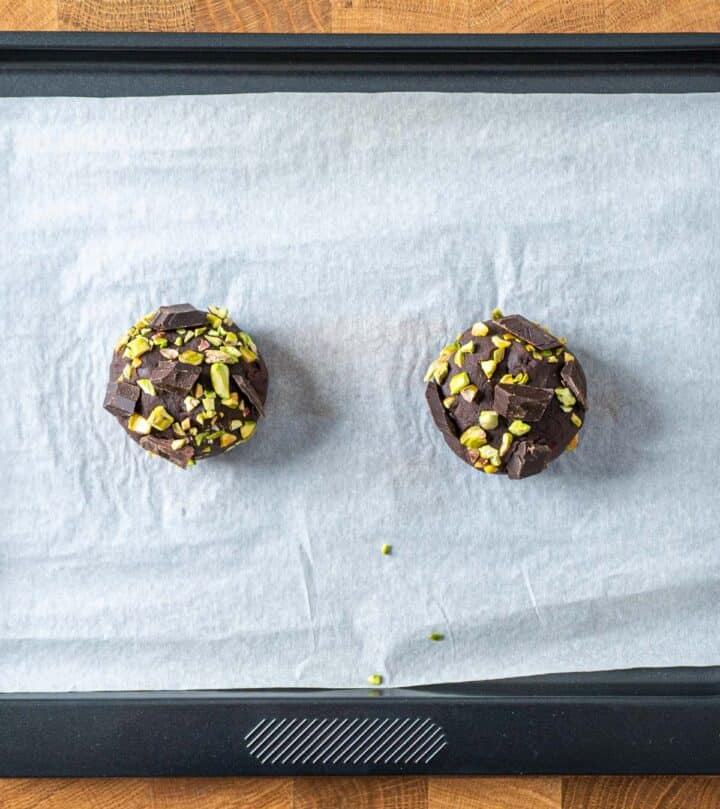 Chocolate pistachio cookies baking on tray.