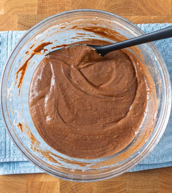 Mixing melted chocolate into whipped eggs for rich, glossy chocolate pistachio cookie batter.