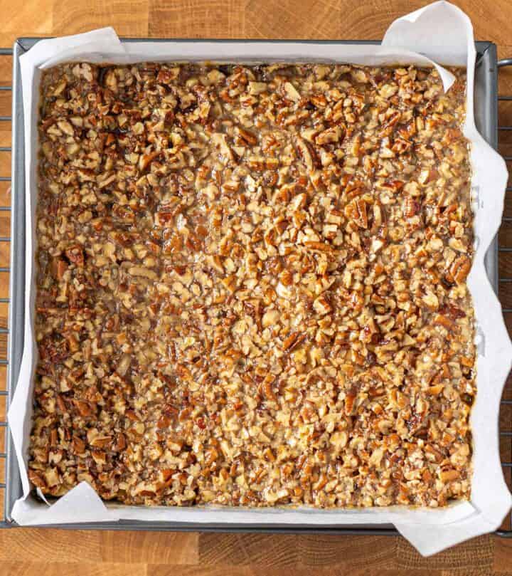 Baked pecan pie cheesecake on a cooling rack.