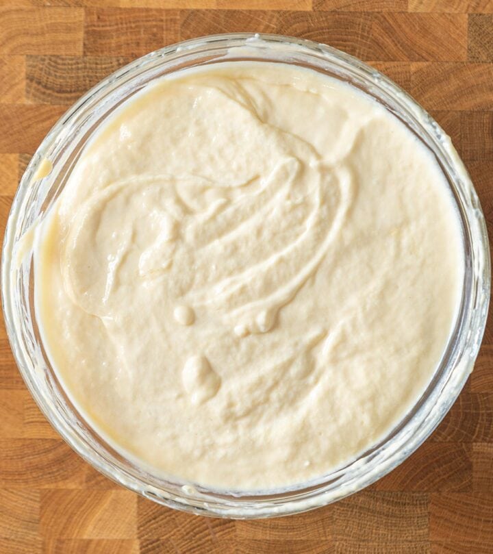 Folding beaten eggs into cheesecake batter.