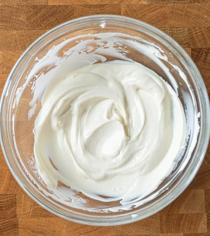 Spreading the sour-cream topping over the hot cheesecake before the brief final bake.