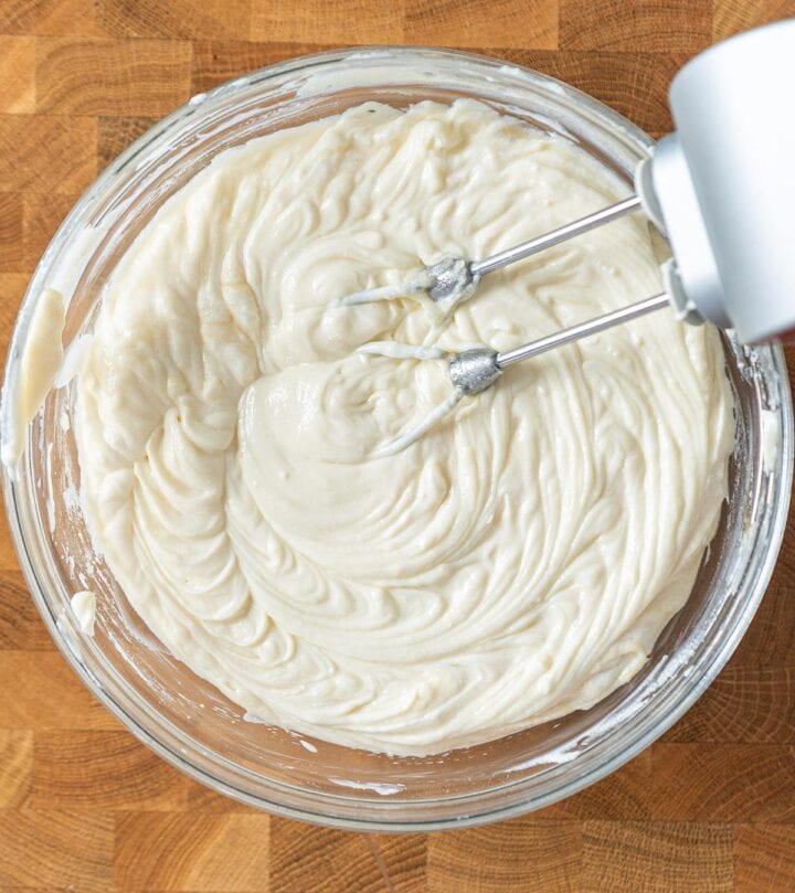Mixing sour cream, sugar, flour, lemon juice, and vanilla gently into the cream cheese.