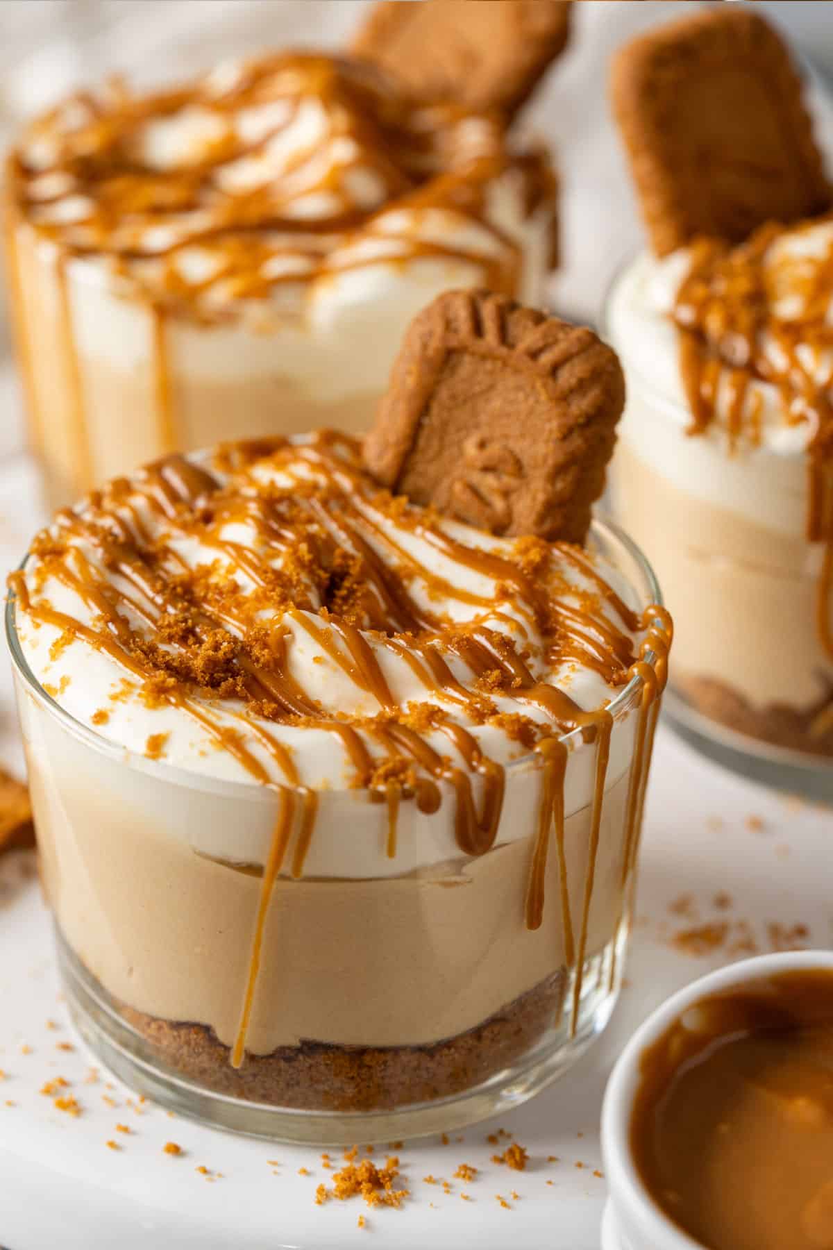 No bake Biscoff cheesecake cups with a bowl of Biscoff spread.