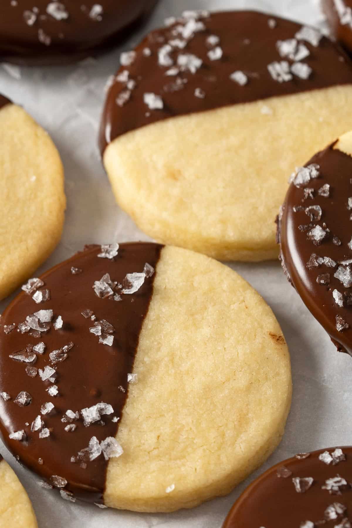 Chocolate dipped shortbread cookies on parchment paper.