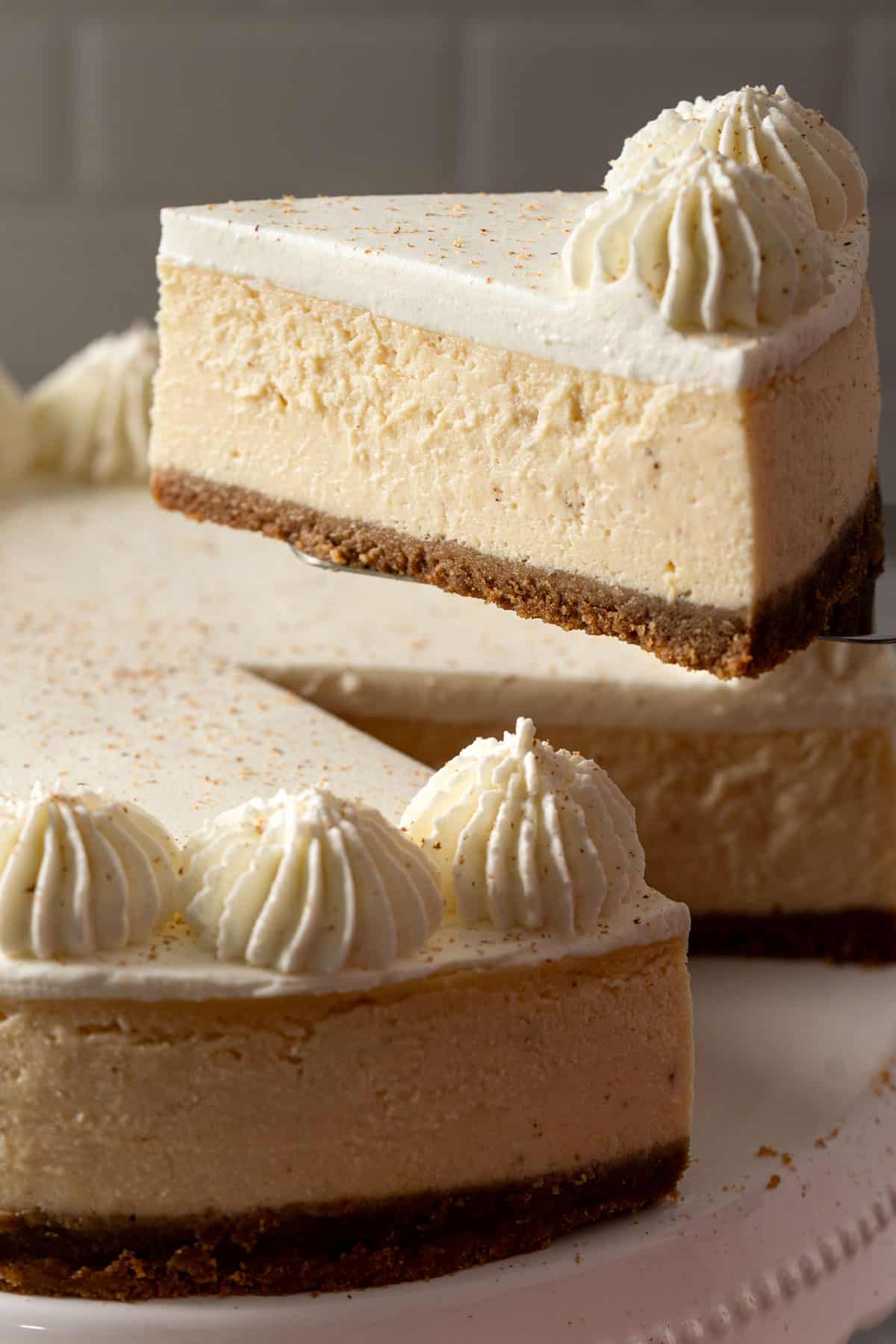 Lifting a slice of the cheesecake.