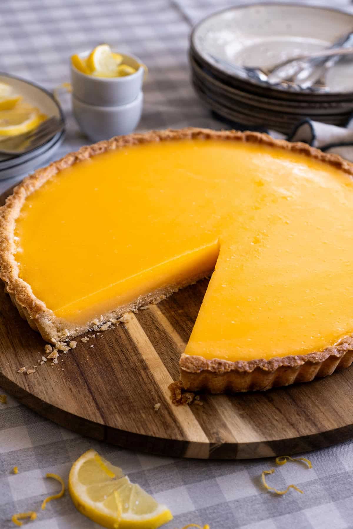 Best lemon tart recipe with lemon tart on a serving plate.