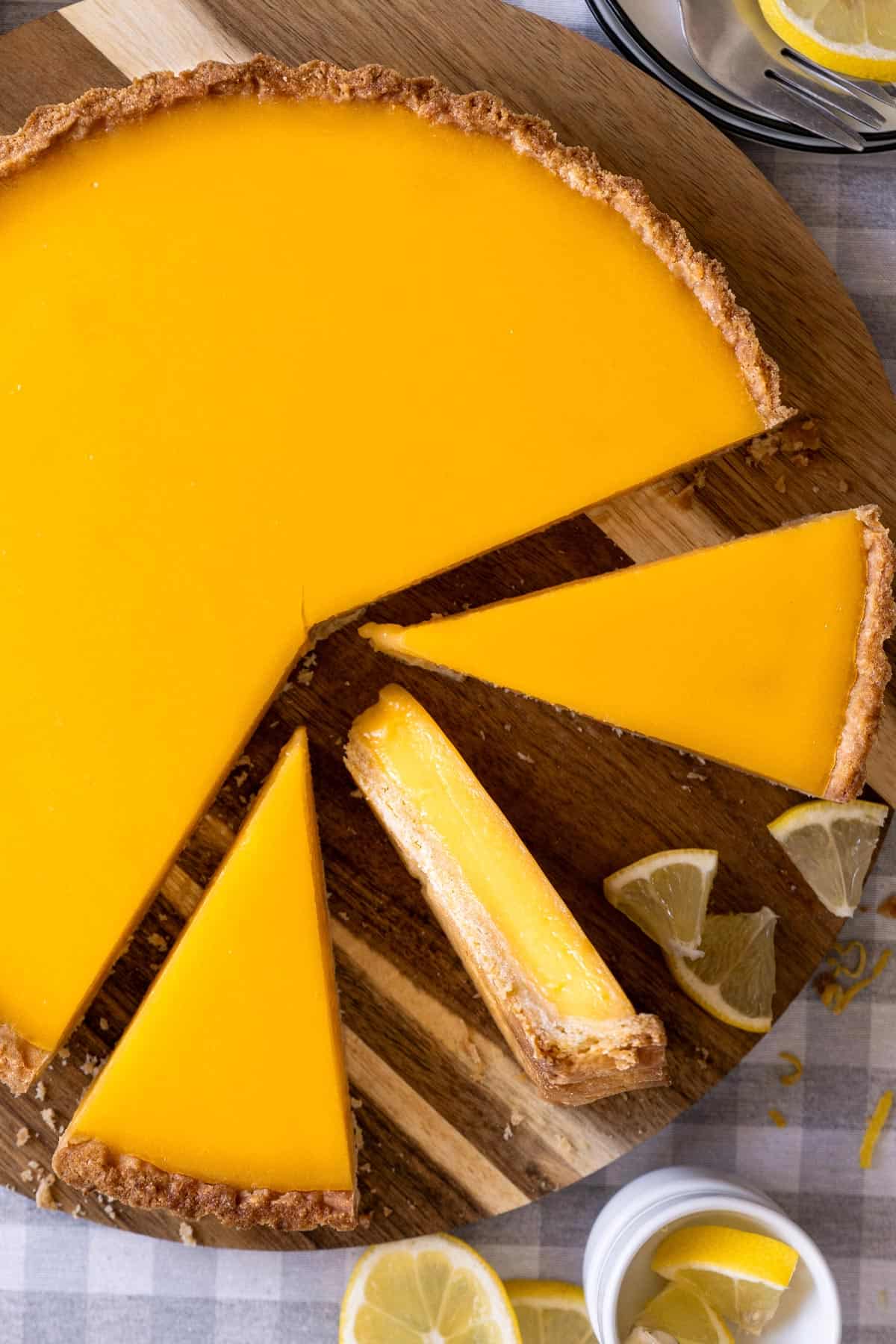 Lemon tart with sliced portions on a serving plate.