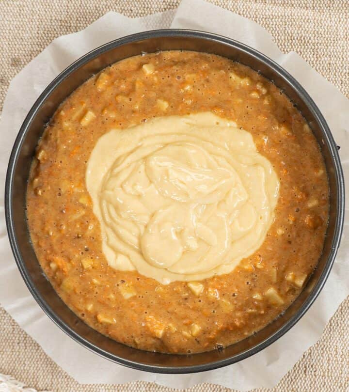 Second layer, pouring cheesecake batter over carrot cake batter.