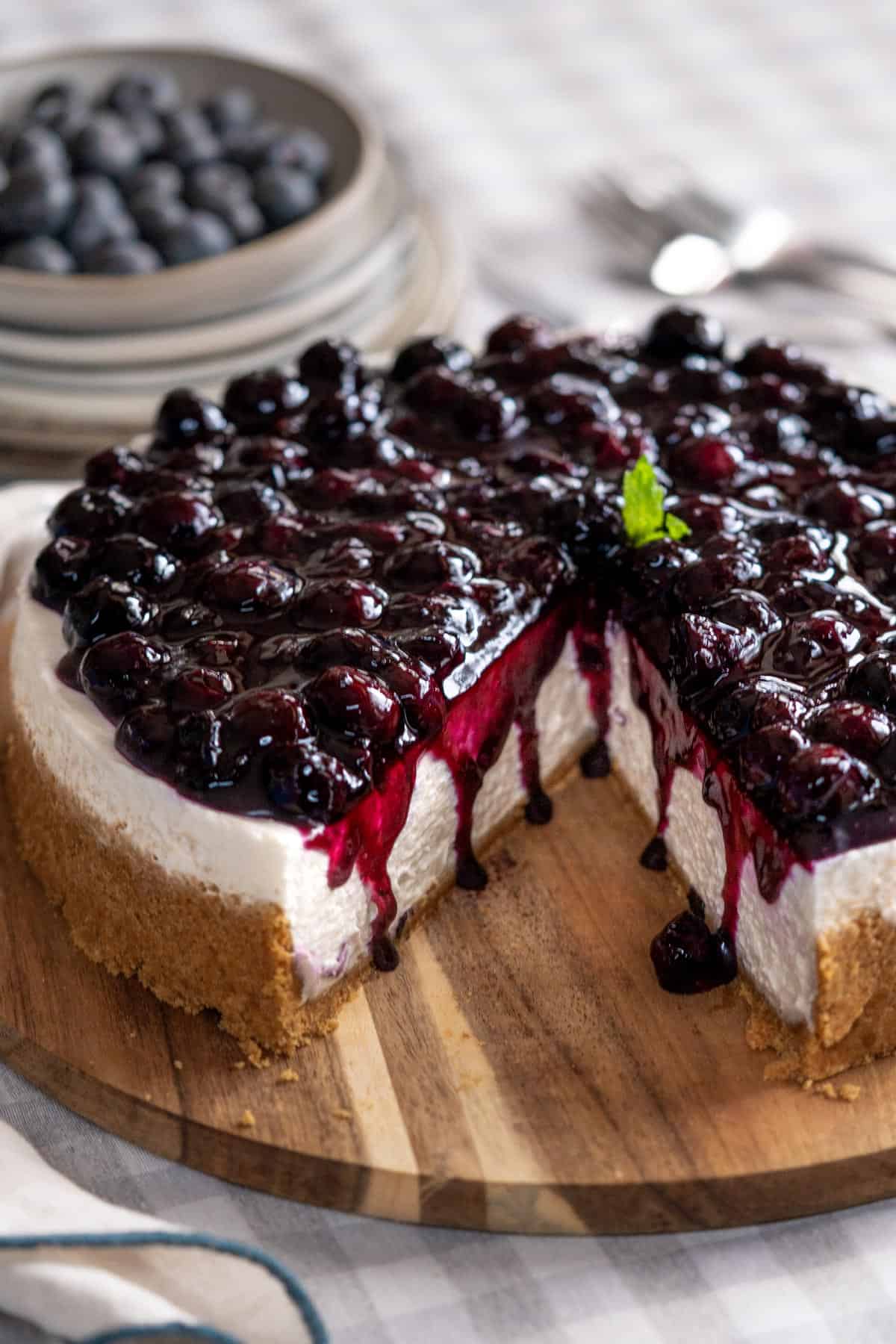 No-bake blueberry cheesecake on a serving plate with a portion missing.