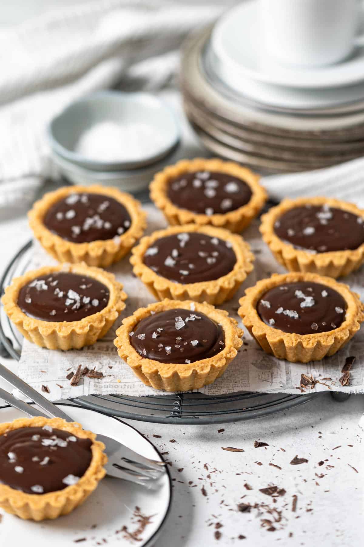 Mini chocolate tarts on a cooling rack.