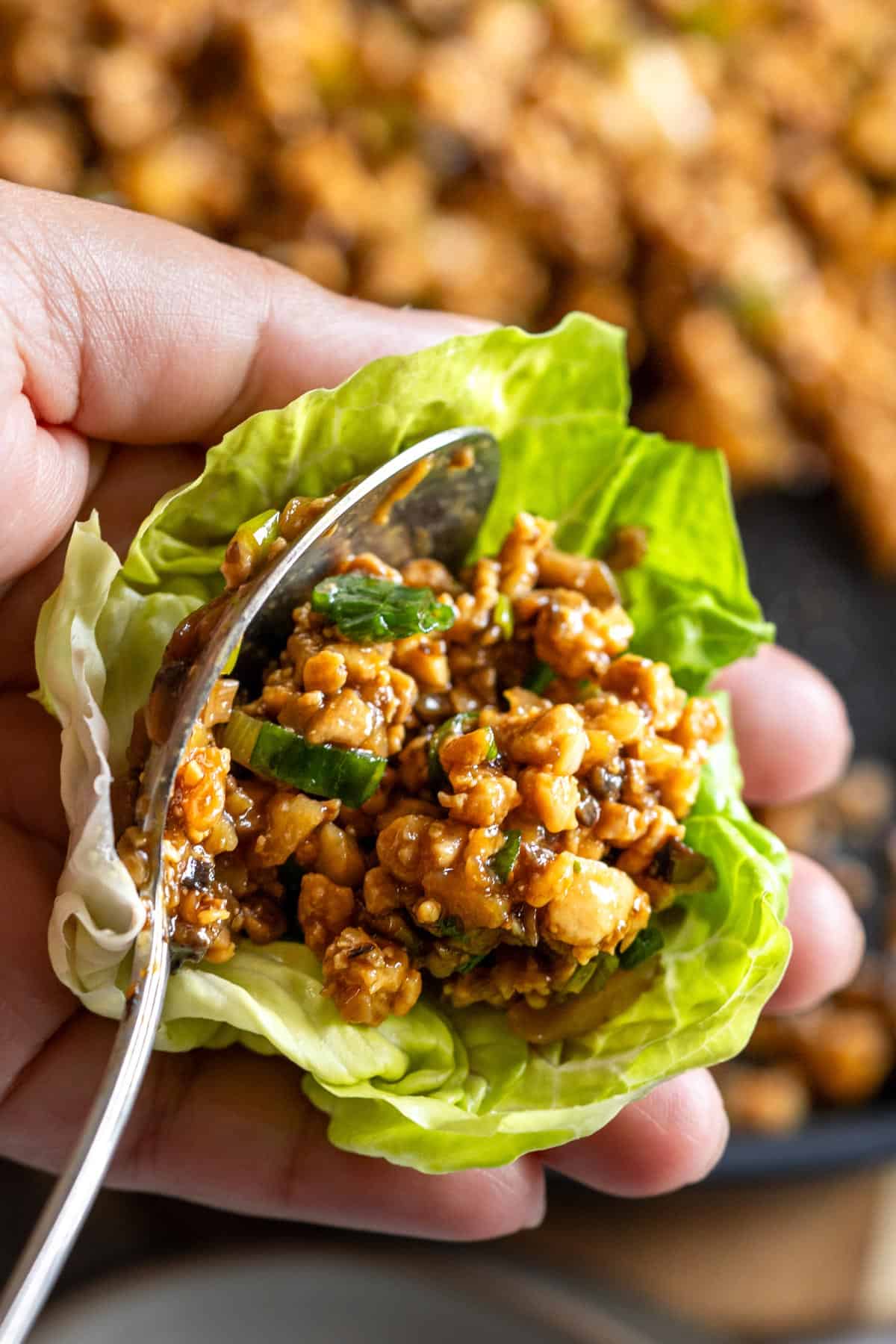 Spooning the filling into the lettuce.