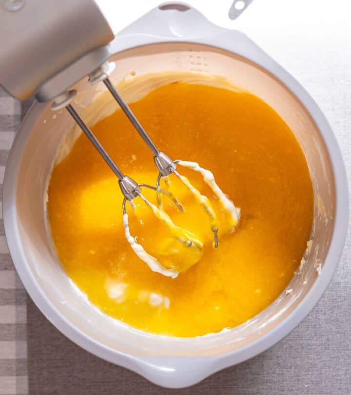 Mixing mango puree into cream cheese mixture.
