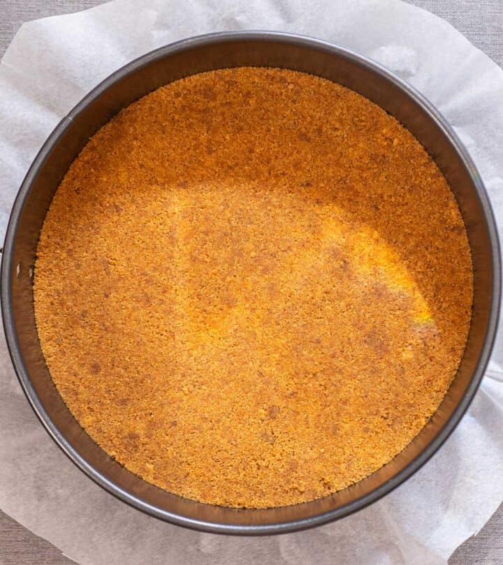 Pressing the crumbs into the pan.