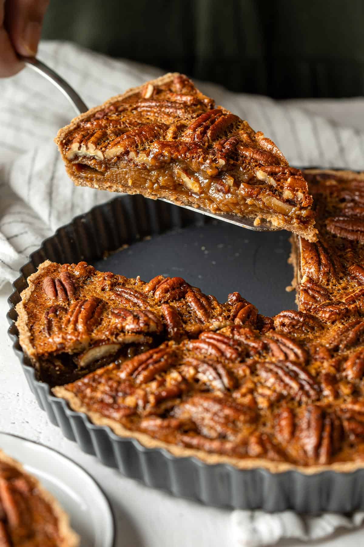 Holding a slice of maple pecan pie showing it's gooey filling