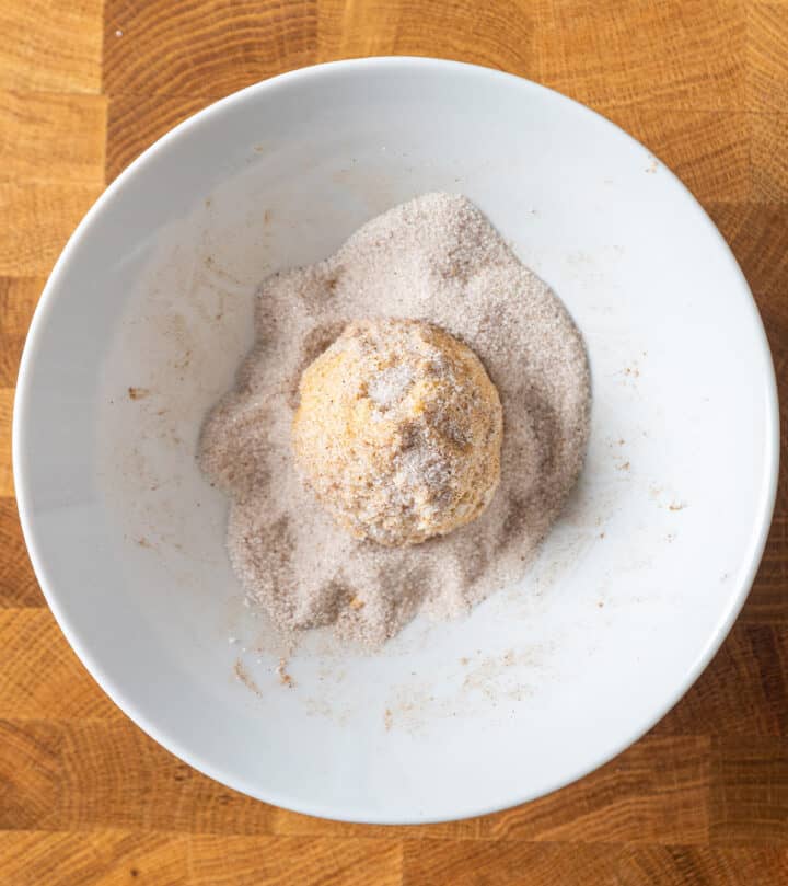 Rolling a cookie ball in spiced sugar.